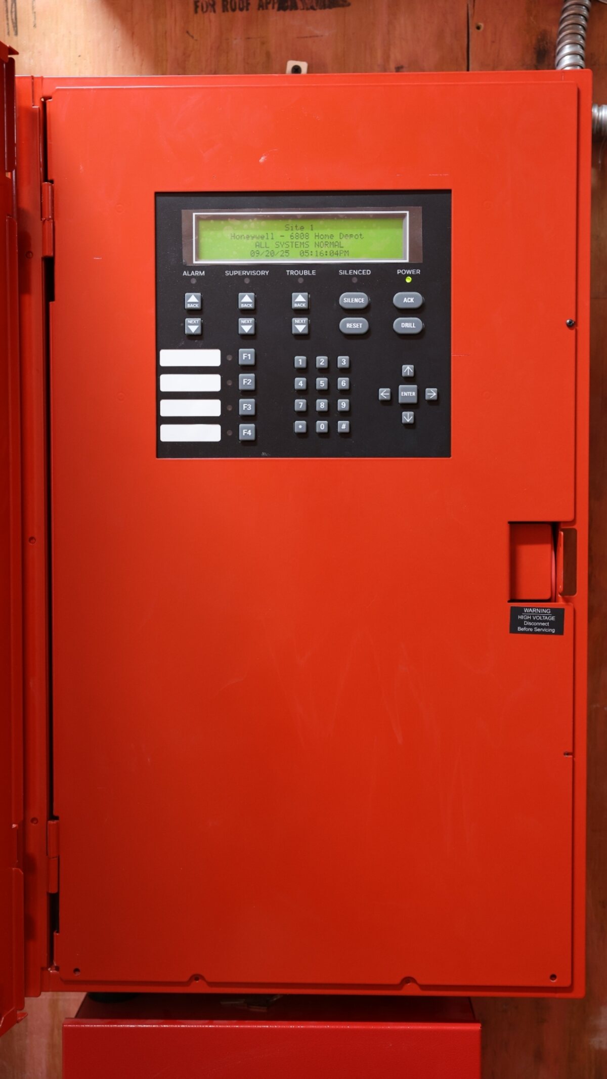 Addressable fire alarm control panel front detail — loop status, LCD display, and Zion inspection sticker