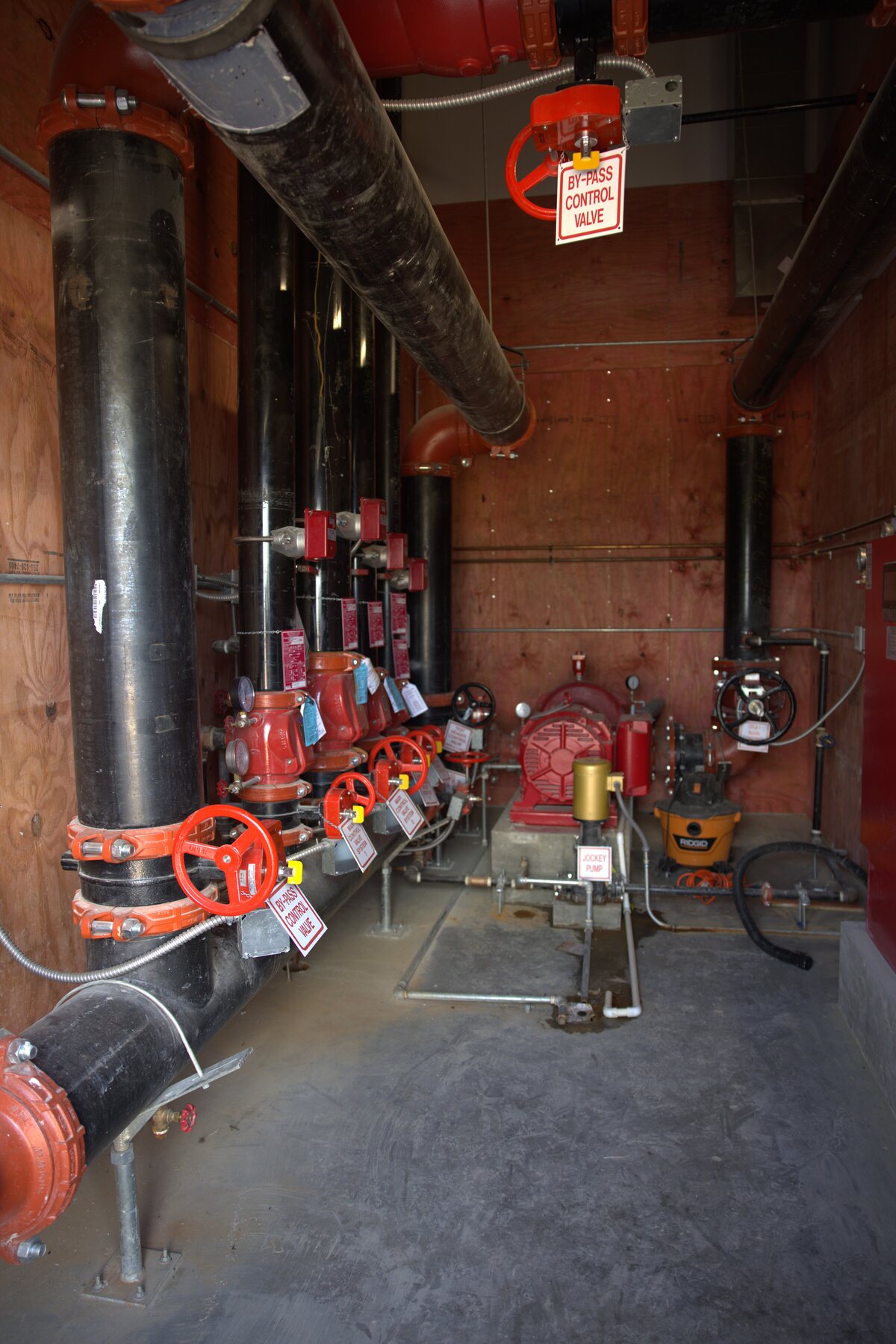 Fire pump room at a Texas commercial facility with diesel-driven pump, cast-iron suction and discharge manifolds, jockey pump, and controller — Zion-inspected installation